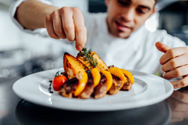 shot of a young chef decorating meal in the kitchen
