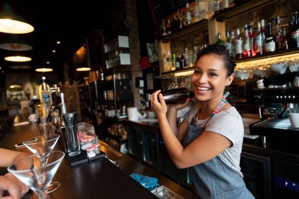 portrait of a happy female bartender mixing drinks at a bar in a cocktail mixer