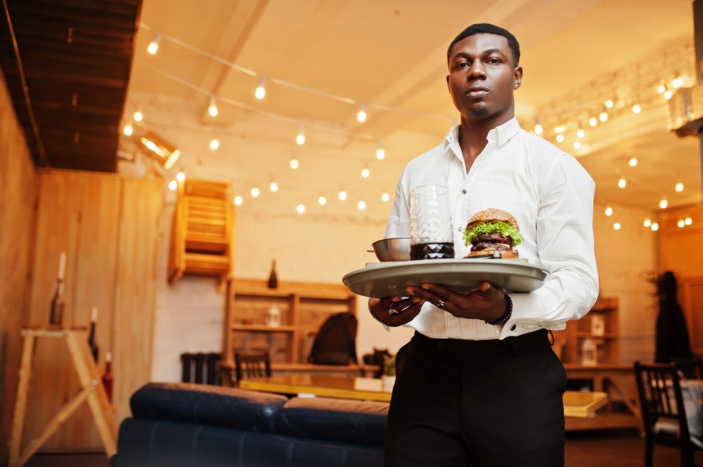 young african american waiter man hold tray with burger at resta