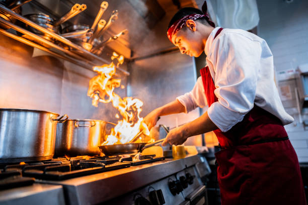 young chef making food on commercial kitchen stove